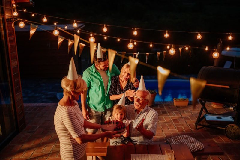 Family Celebrations with String Lights Near Pool Area